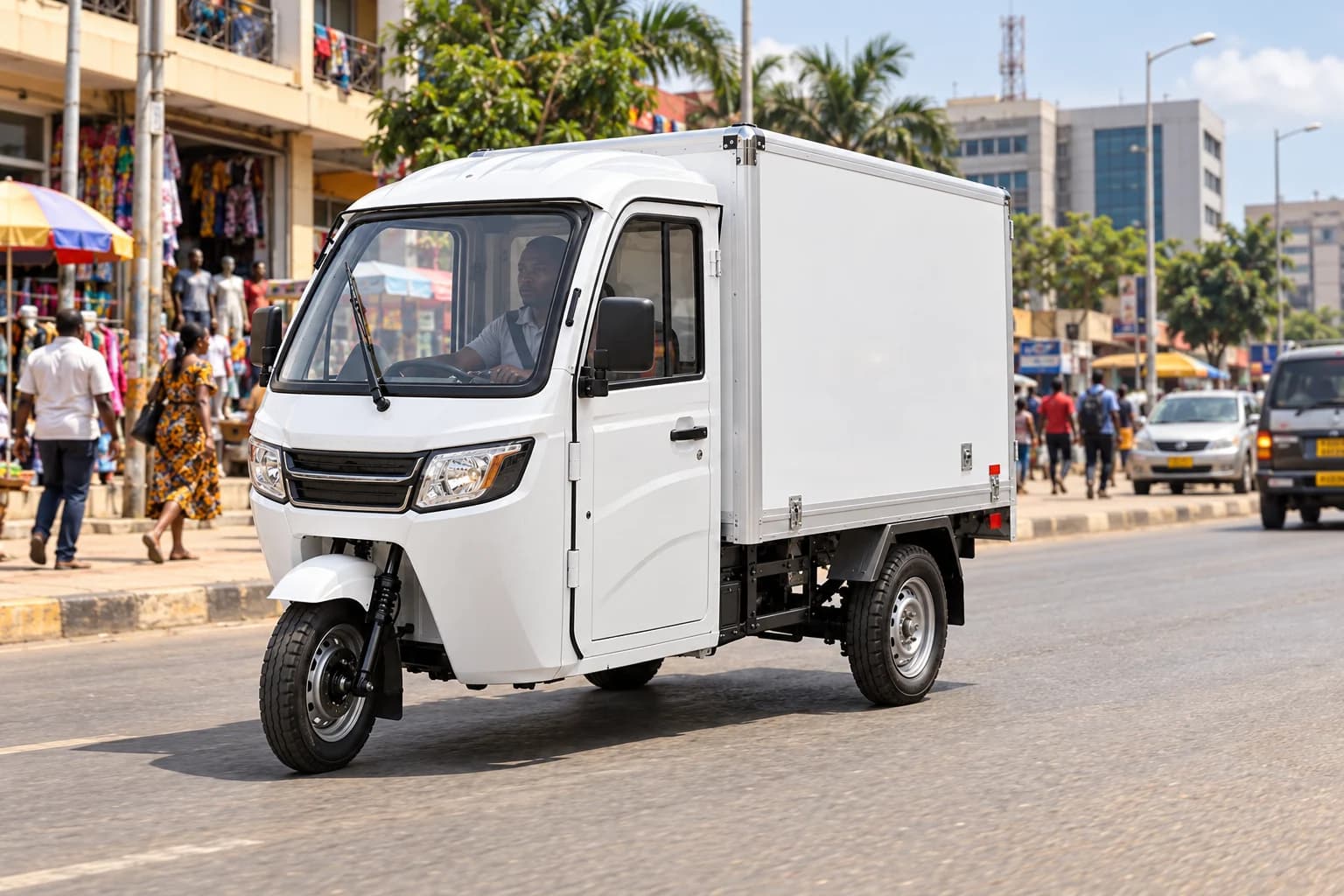 White boxed electric Aboboyaa cargo tricycle operating on a commercial street in Accra Ghana